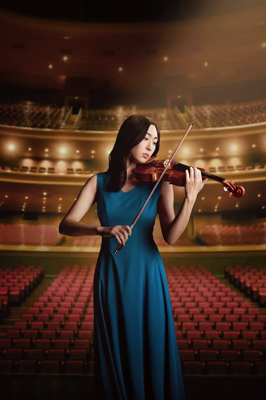 A violinist on stage in a concert hall